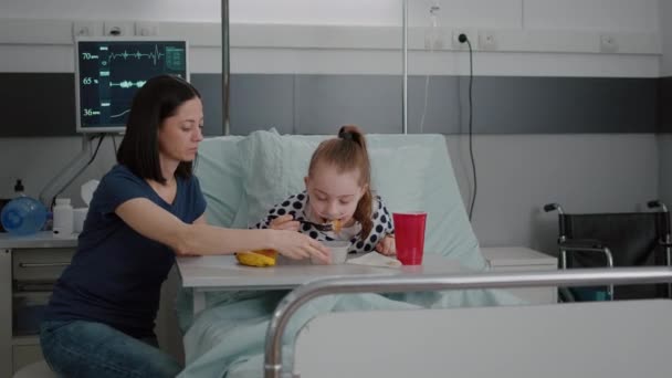 Madre in piedi con la ragazza malata mentre mangia cibo sano durante il pranzo in attesa di competenze mediche — Video Stock