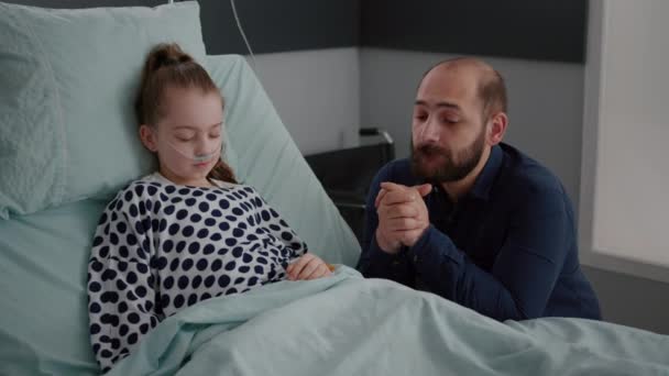 Niña enferma hija con tubo nasal de oxígeno acostada en la cama durmiendo durante el examen de recuperación — Vídeos de Stock
