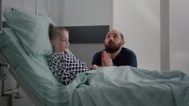 Beteg lány lánya alszik a műtét után gyógyulás, miközben aggódik apa imádkozik a gyerek egészségügyi — Stock videók