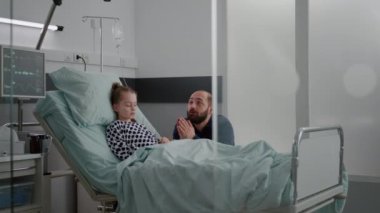 Hastalık teşhisini beklerken dua eden üzgün baba.