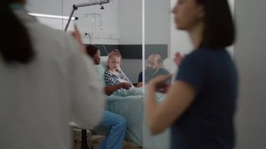 Afro-amerikan pratisyen asistan hasta belirtilerini panoya yazıyor.