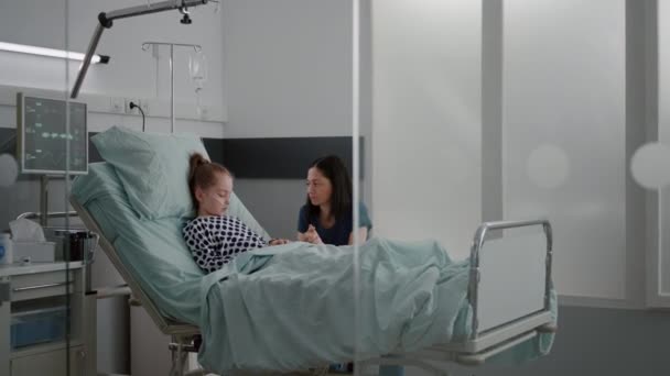 Worried mother standing with daughter praying while sleeping after recovery surgery — Stock Video