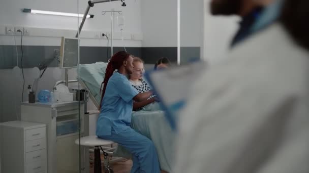 Asistentă medicală afro-americană care prezintă radiografia plămânilor explicând simptomele bolilor respiratorii — Videoclip de stoc