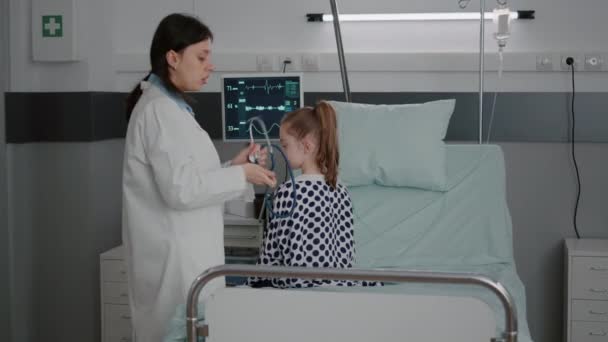 Médica pediatra examinando paciente doente usando estetoscópio médico — Vídeo de Stock
