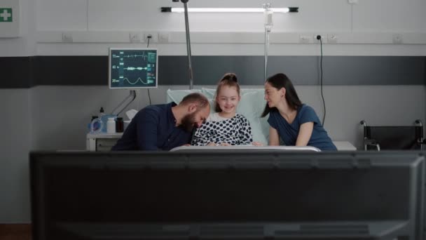 Семья смотрит развлекательный мультфильм по телевизору в больничной палате — стоковое видео