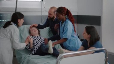 Kalp atışlarını izleyen küçük bir çocuğu durdurmaya çalışan tıbbi ekip.