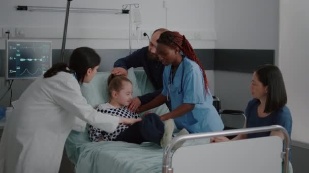 Больничная больная девочка страдает от болевого приступа, пока медицинская команда держит — стоковое видео