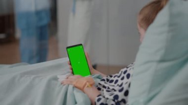 Elinde küçük bir çocuk yeşil ekran kroma anahtar telefonuyla izole edilmiş görüntüler tutuyor.
