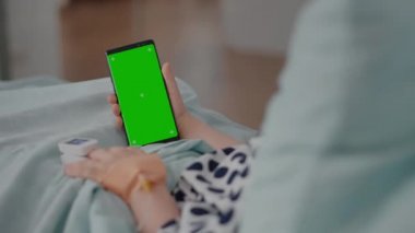 Hasta kızın elinde yeşil ekran kroma anahtar telefonu var ve iyileşme sürecinde izole edilmiş görüntüsü var.