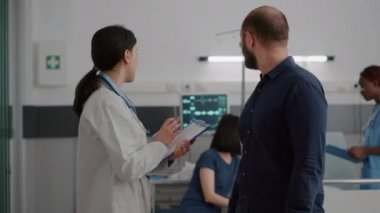 Pratisyen kadın doktor, iyileşme sürecinde endişeli babayla tıbbi uzmanlığı tartışıyor.