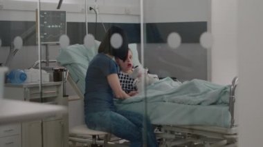 İyileşme sürecinde tıbbi bir ameliyat geçirdikten sonra hastanede yatan hasta çocuk dinleniyor.