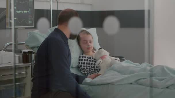 Vader houdt zieke dochter hand uitleggen medicatie behandeling tegen medische ziekte — Stockvideo