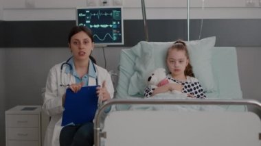 Pov çocuk doktoru kadın doktor uzak bir aileye sağlık tedavisini açıklıyor