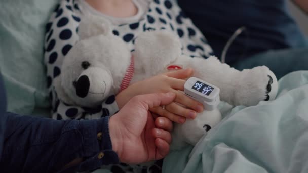 Primer plano del padre sosteniendo las manos de la hija enferma después de sufrir una cirugía médica contra la infección por enfermedad — Vídeo de stock