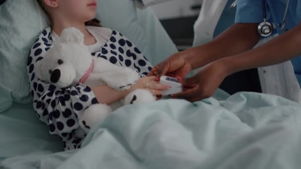 Close-up de enfermeira afro-americana colocando oxímetro médico no dedo da criança — Vídeo de Stock