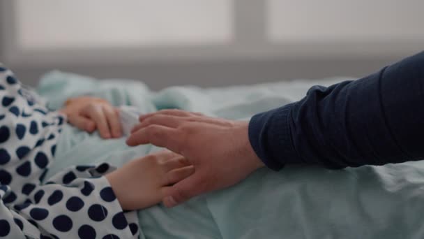 Closeup of sick child resting in bed with oximeter on finger monitoring heartbeat pulse — Stock Video