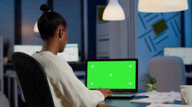 Yeşil ekranlı dizüstü bilgisayara bakan siyahi iş kadınının arka planı