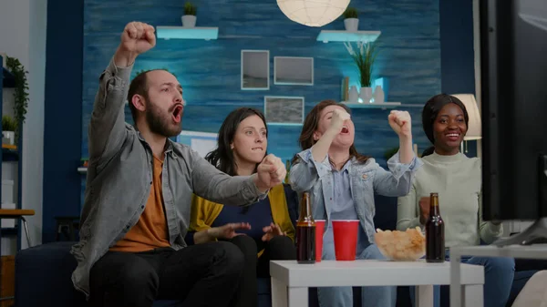 Mixed race friends relaxing on couch while watching football game — Stock Photo, Image