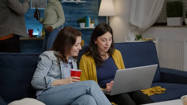 Багатоетнічні жінки насолоджуються часом разом, дивлячись фільм на ноутбуці — стокове фото