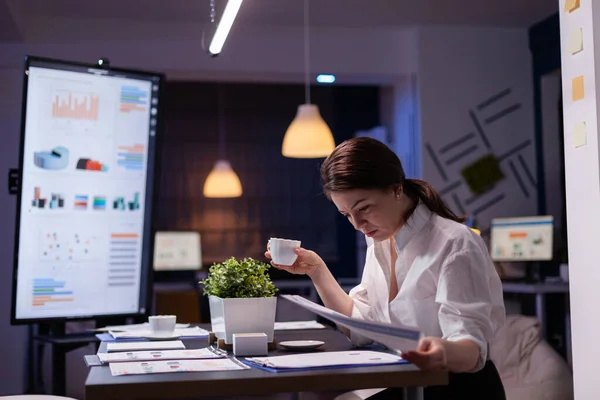 Workaholic donna d'affari guardando le relazioni di presentazione sul monitor a confronto con grafico finanziario — Foto Stock