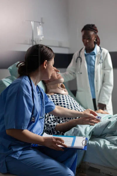 Medical assistant checking oximeter attached to senior man — Stock Photo, Image