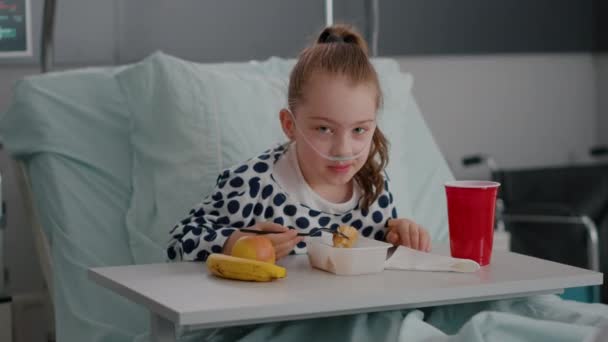 Portret van een klein kind in het ziekenhuis dat in bed ligt in de onderzoekskamer voor herstel — Stockvideo