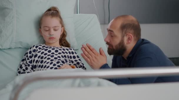 Zmartwiony ojciec modli się za chorą córkę zdrowie córki po operacji medycznej — Wideo stockowe