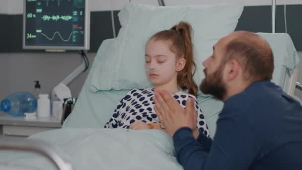 Beteg lánya alszik, miközben aggódik szomorú apa imádkozik egészségügyi helyreállítási — Stock videók