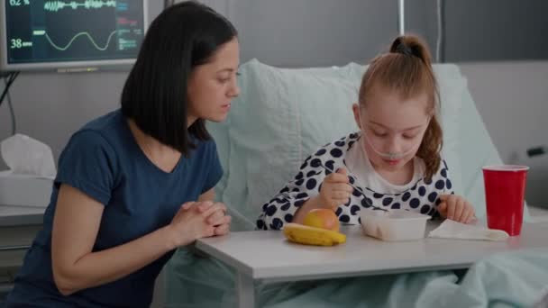 Matka sedí vedle nemocné dcery při jídle oběd zotavuje po lékařské operaci — Stock video