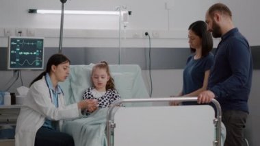 Çocuk doktoru kadın doktor küçük çocuk hasta parmağına oksimetre takıyor.