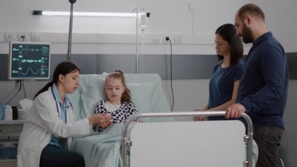 小児科医の女性医師は、小さな子供の患者の指に医療酸素計を置きます — ストック動画