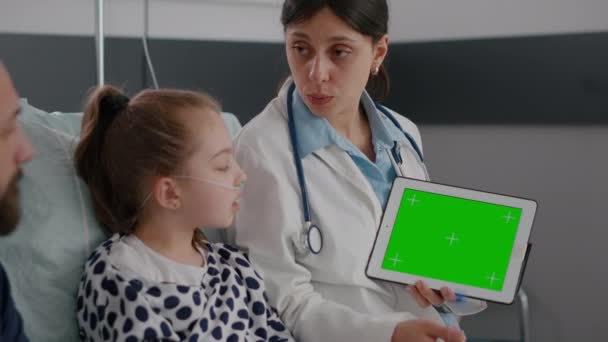 실용 의사가 녹색 화면 크로마 키 태블릿을 모조로 사용하여 질병 전문 지식을 설명하는 모습 — 비디오
