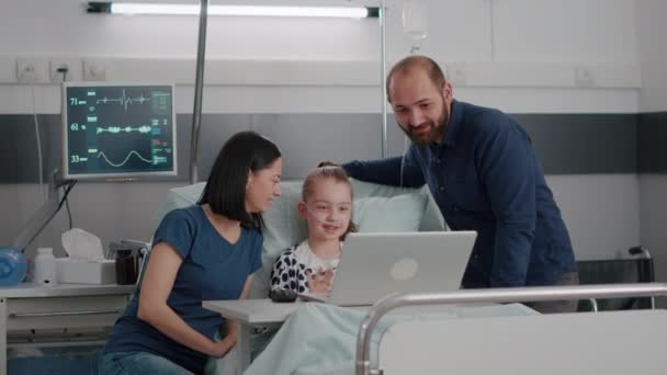 Familie zit naast kleine dochter begroeten vrienden tijdens online videocall conferentie — Stockvideo