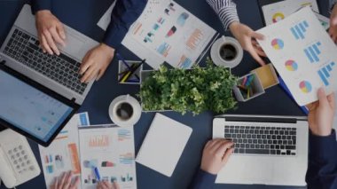 Takım çalışmasının üst görünümü finans şirketinin evraklarını paylaşarak yönetim istatistiklerini tartışır