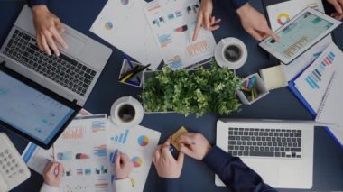 Masanın üzerine mali evrakları açıklayan yapışkan notlar koyan işadamlarının en üst görünümü