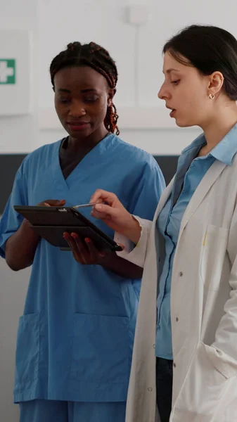 Afrikaanse amerikaanse arts verpleegkundige controleren van de ziekte expertise op tablet — Stockfoto