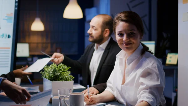 Porträt einer lächelnden Geschäftsfrau, die in die Kamera schaut und Überstunden in einem Besprechungsbüro macht — Stockfoto