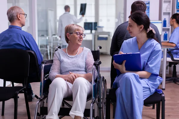 Подача документів медсестри під час розмови з інвалідністю старша жінка — стокове фото