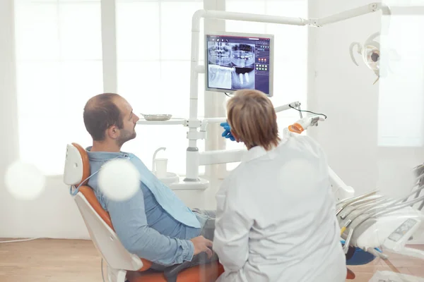 Stomatologo discutere con il paziente seduto sulla sedia stomatologica — Foto Stock