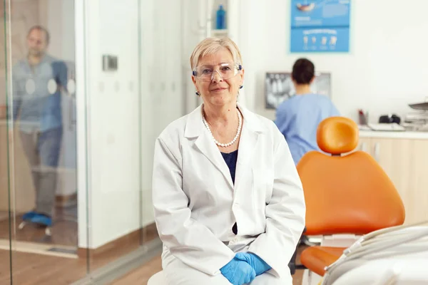 Стоматологічний лікар дивиться в камеру в очікуванні пасивного обстеження. — стокове фото