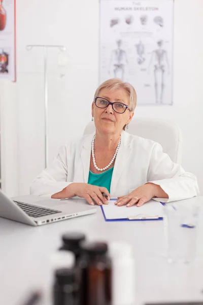 Портрет лікаря-практика, який дивиться в камеру, сидить за столом у конференц-залі — стокове фото