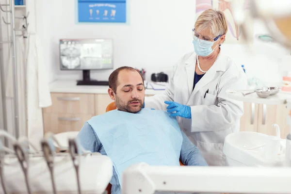 歯科手術後に立ち上がるために患者を助ける高齢の胃科医 — ストック写真