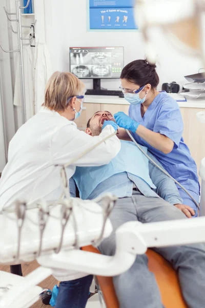 Старшая женщина стоматолог анализа с зеркалом больной зуб пациента здоровья — стоковое фото