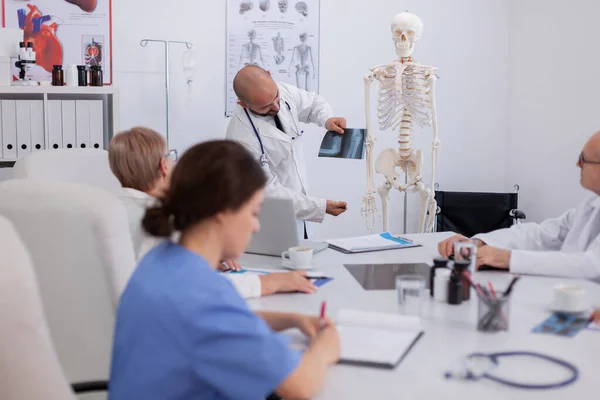 Médecin spécialiste médecin expliquant la structure de l'anatomie corporelle en utilisant la radiographie — Photo