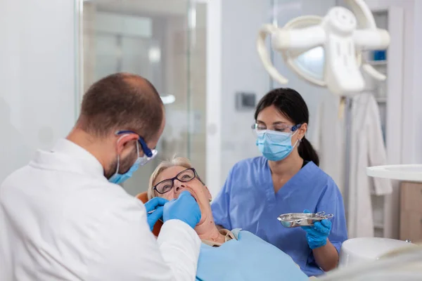 Estomatólogo con asistente de colocación de sello dental — Foto de Stock