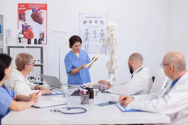 Hospital woman nurse presting bone structure using body anatomy skeleton