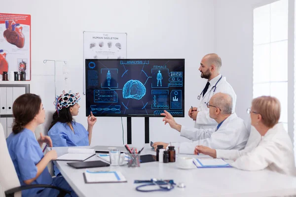 신경 학자 남성 의사는 여성 기생충에 대한 센서가 부착 된 헤드셋을 사용하여 뇌 전문 지식을 확인 한다 — 스톡 사진