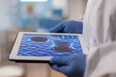 DNA taramasıyla tablet üzerinde çalışan kimyager doktorunu kapatın.
