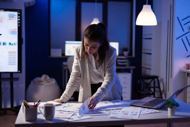 Finansal raporlar üzerinde çalışan meşgul bir iş kadını.