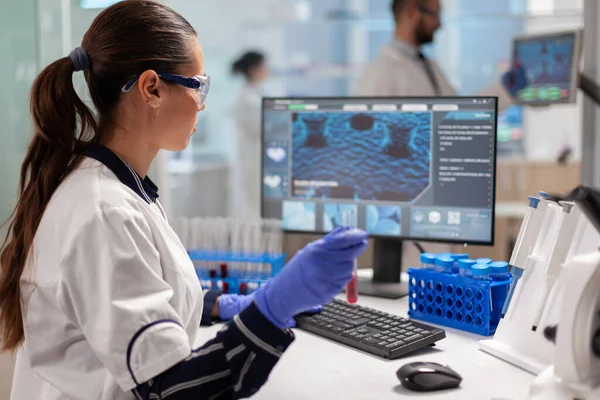 Chimica medico analizzando il campione di sangue e digitando sul computer — Foto Stock